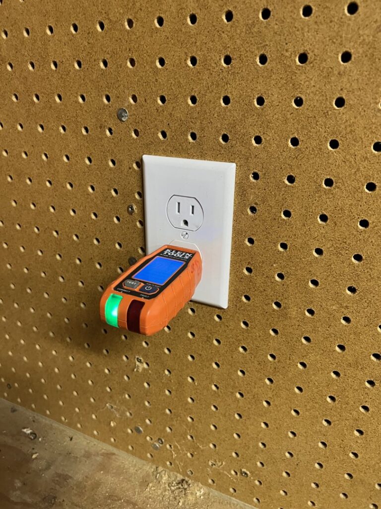 An electrician from Circuit Masters, Inc. testing an electrical outlet with a tester in Billings, MT.