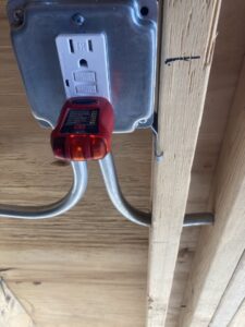 An electrician from Diaz Techician LLC in Chicago, IL, using an outlet tester to check an electrical receptacle.