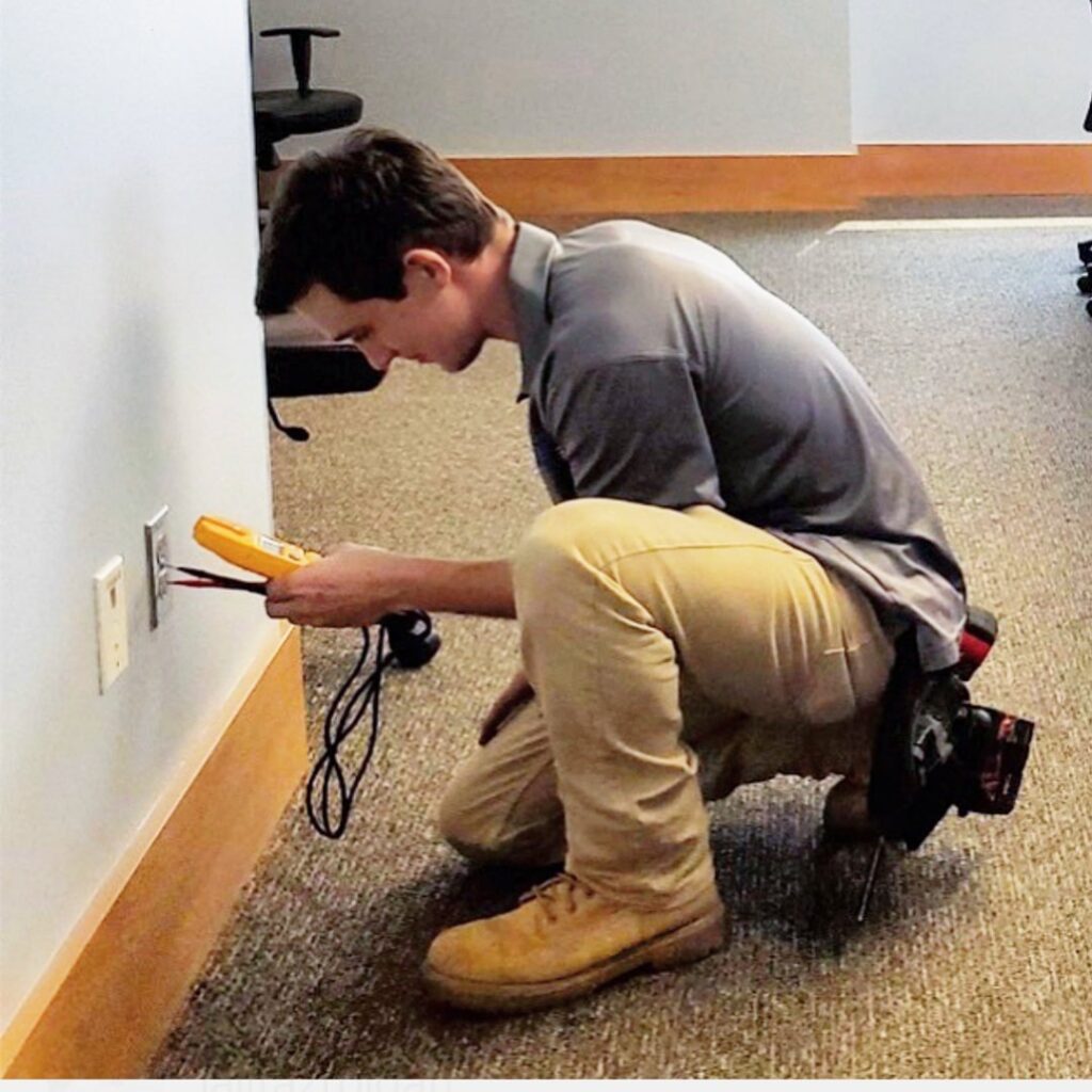 An electrician from Fuller Electrical Contractors, Inc. testing an electrical outlet with a multimeter in Oldsmar, FL.