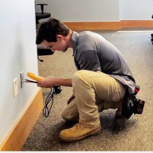 An electrician from Fuller Electrical Contractors, Inc. testing an electrical outlet with a multimeter in Oldsmar, FL.