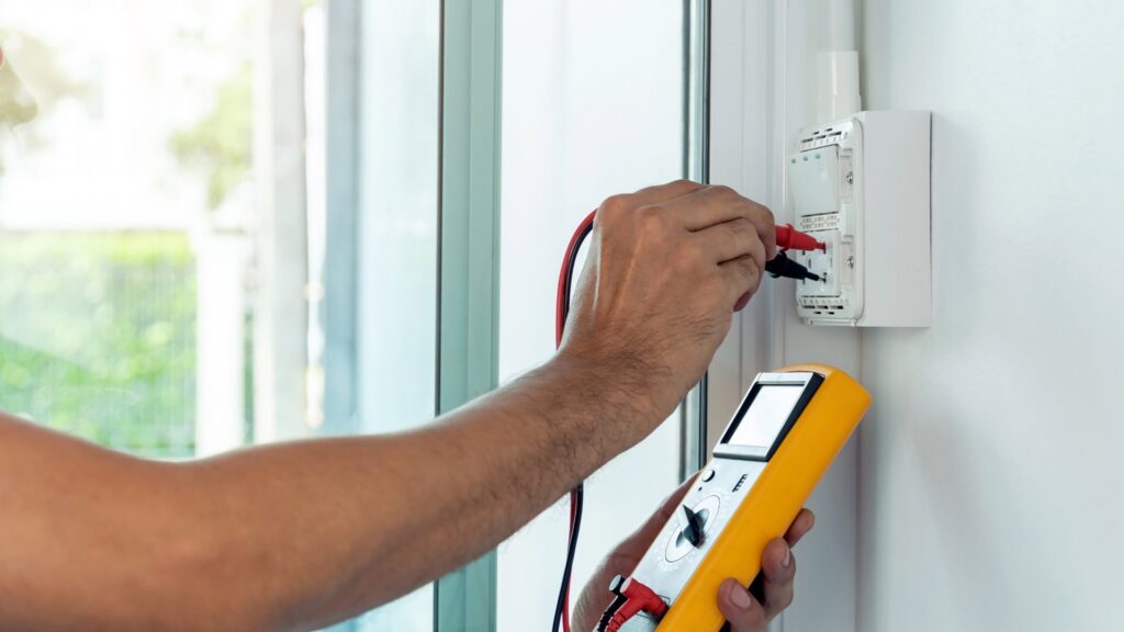 An electrician testing an electrical outlet with a multimeter at Generators Sets in Hialeah, FL.