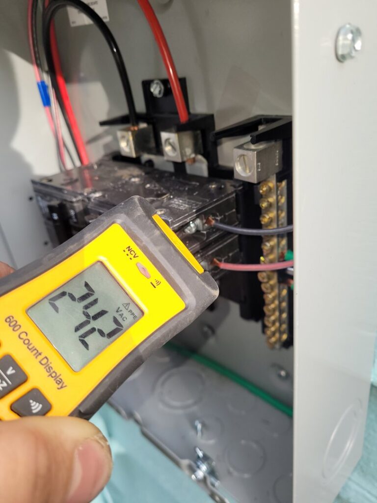 An electrician using a multimeter to test voltage inside an electrical panel, performed by Ant Power Electric in Tacoma, WA.