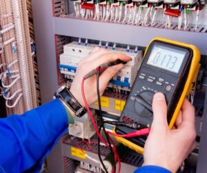 An electrician testing an electrical panel with a multimeter for Black Bear Electric in Aurora, CO.