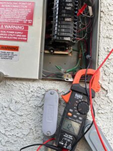 An electrician from Eco Electric testing an electrical panel with a clamp meter in Las Vegas, NV.