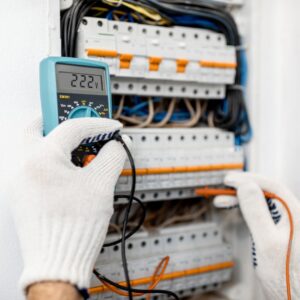 An electrician testing an electrical panel with a multimeter at Generators Sets in Hialeah, FL.