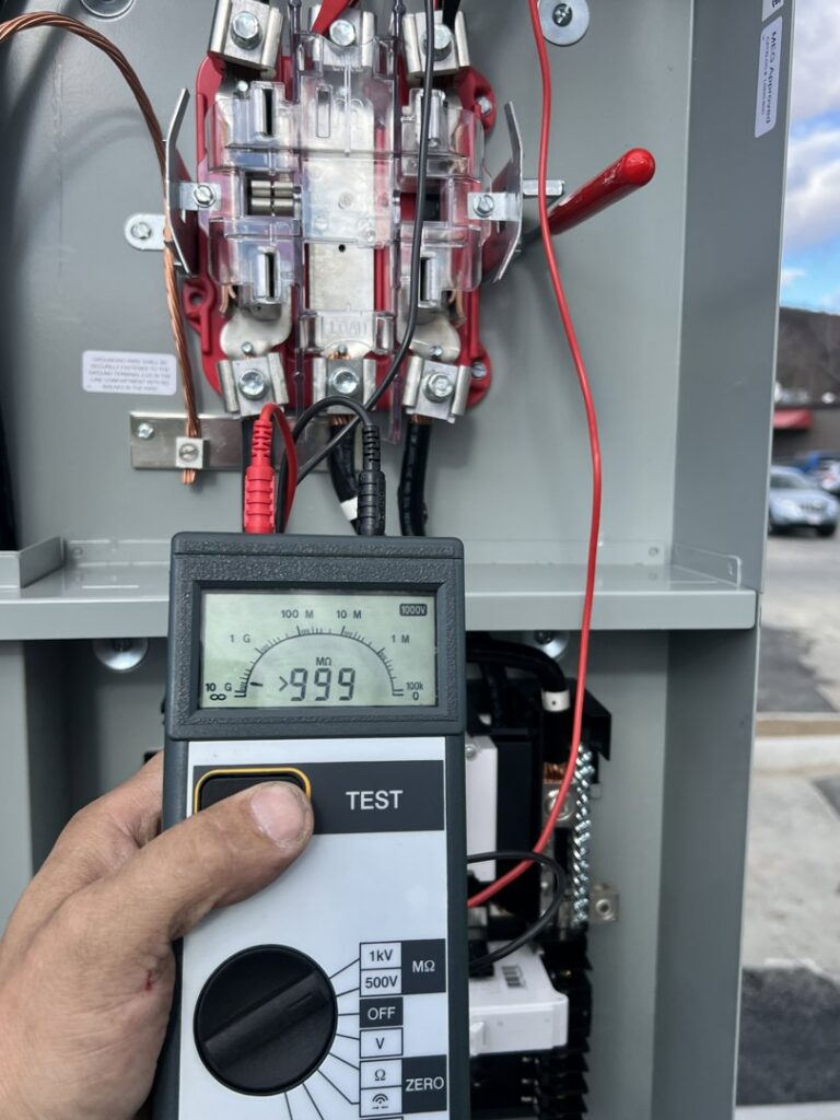 An electrician using a multimeter to test connections inside an electrical panel, performed by Peeler Electric Light & Power in Merrimack, NH.