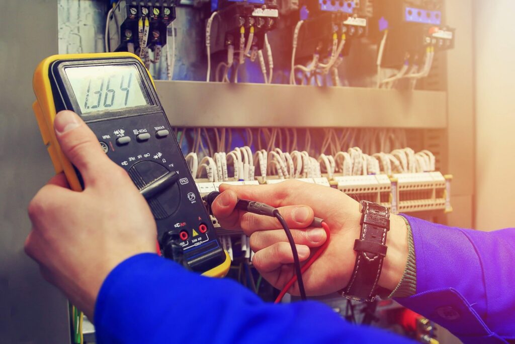 An electrician using a multimeter to test an electrical panel for Polsley Electric Company in Omaha, NE