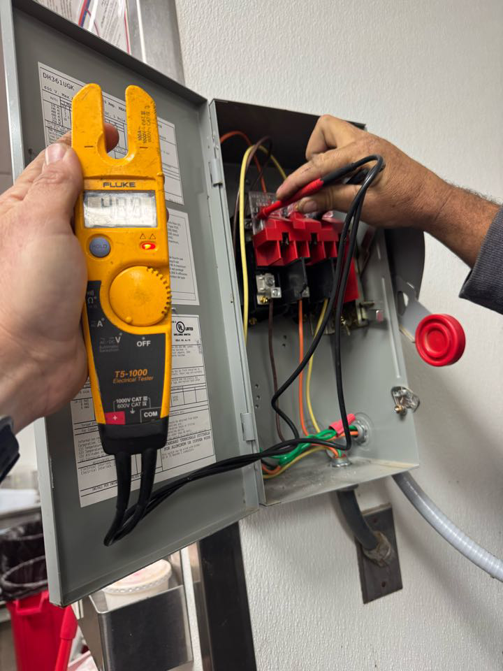 An electrician testing an electrical panel with a multimeter at Electric Service & Repair, Inc in Miami, FL.