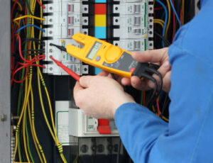 An electrician using a multimeter to test connections within an electrical panel, a service from Your Gilbert Electrician in Gilbert, AZ.