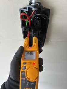 An electrician testing EV charger wiring with a multimeter for ChargerPro in Denver, CO.