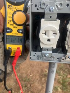 An electrician testing an outdoor electrical outlet with a clamp meter for Goodie's Electrical Contractors LLC in Dothan, AL