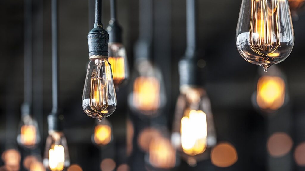 An electrician testing an electrical outlet with a voltage tester at a job site for Dave Hall Electric in Utica, NY.