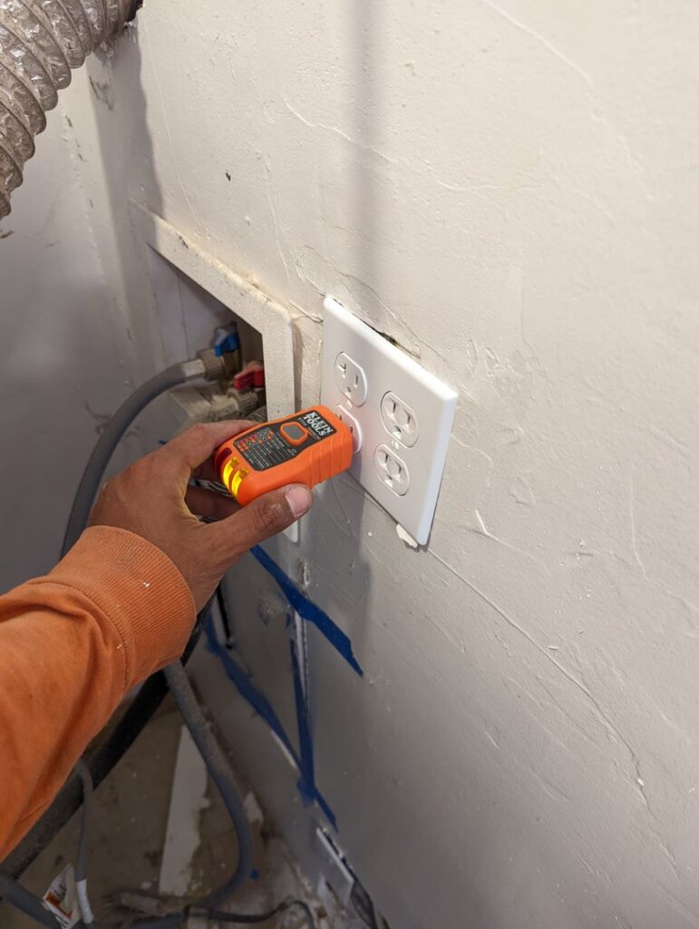 An electrician's hand using an electrical tester on an outlet, demonstrating diagnostic work by Primo's Electrical Services in San Diego, CA.