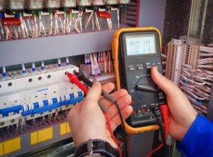 An electrician testing an electrical panel with a multimeter for Cruz Electrical Services in Wilmington, DE.