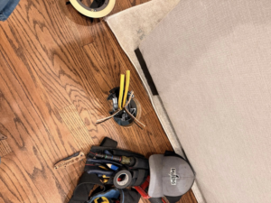 Electrician tools and wires on a wooden floor during a floor outlet installation by Balderas Electric in Austin, TX.