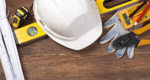 A hard hat, multimeter, and crimping tool, representing the professional electrical work of Corbin & Maille, Inc in Erie, PA.