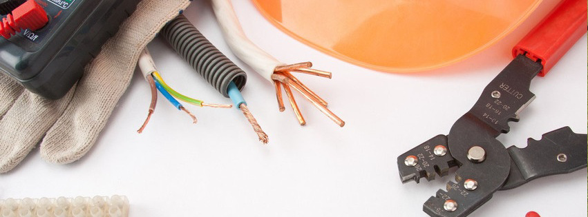 Electrician tools including a multimeter, wires, conduit, wire strippers, hard hat, and gloves for Quality Electric Inc in Wabash, IN.