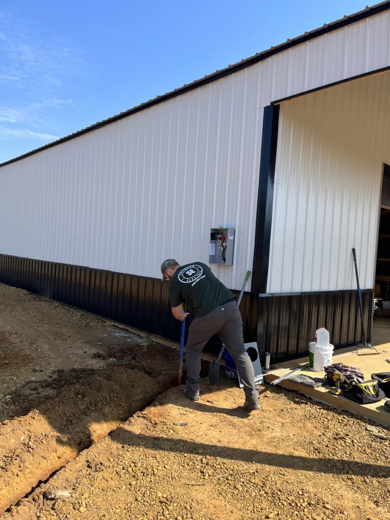 An electrician trenching for underground electrical wiring installation by Spencer Electric in Hopkins, MN.