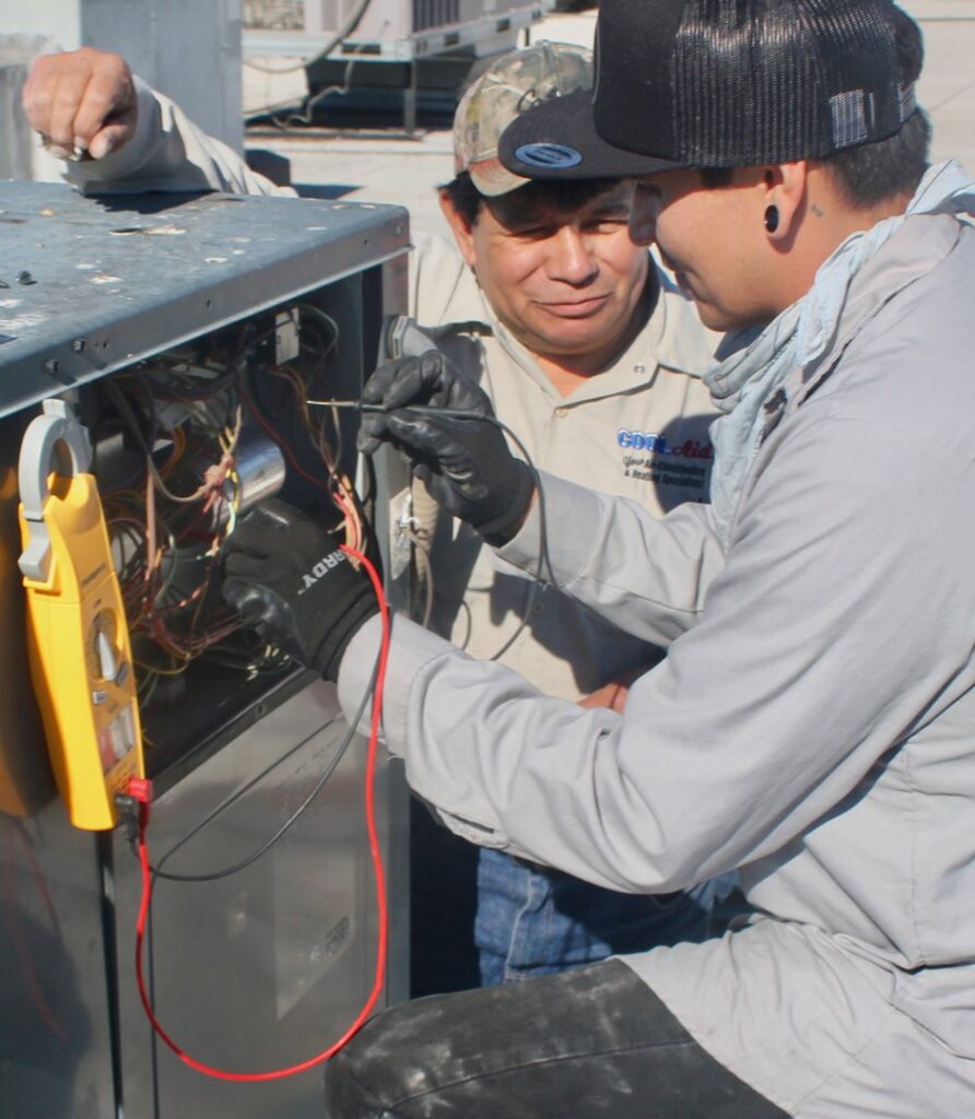 An electrician troubleshooting an AC unit's electrical system with a multimeter for Cool Aid Air Conditioning in Scottsdale, AZ