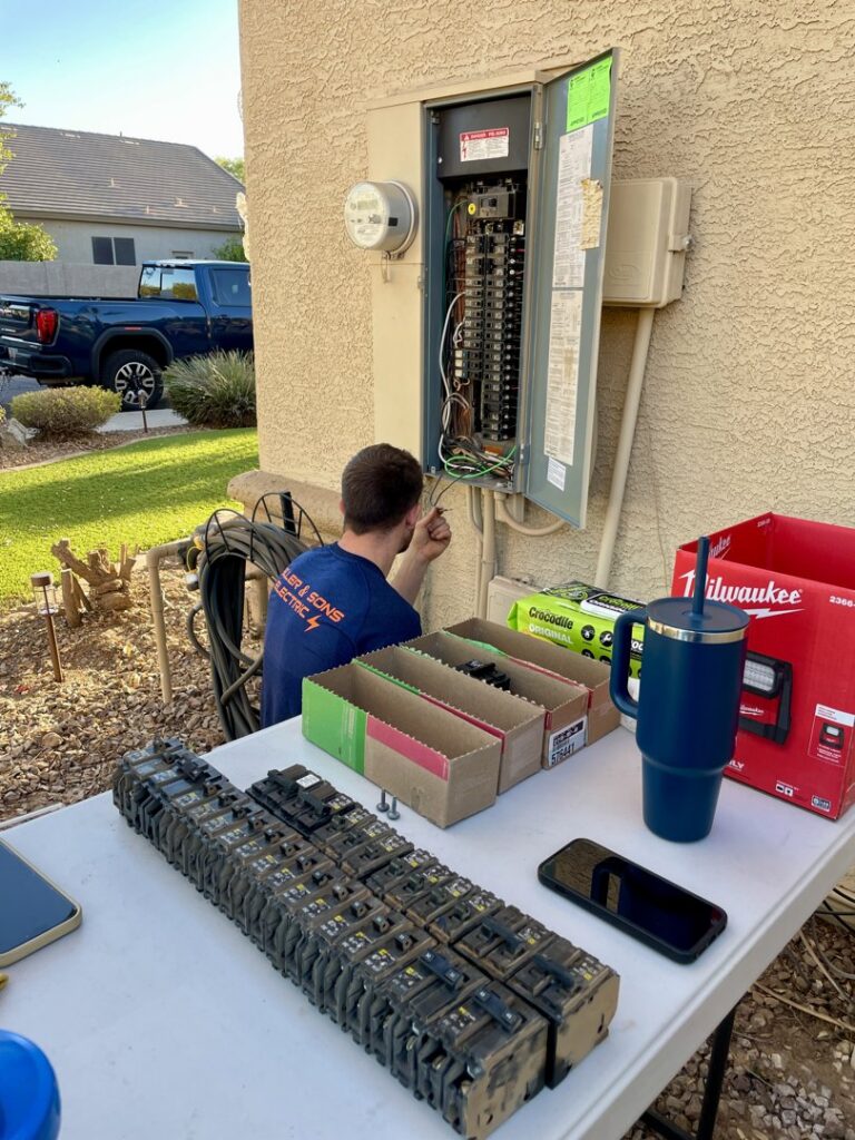 An electrician upgrading an outdoor electrical panel with new breakers for Miller and Sons Electric in North Myrtle Beach, SC.