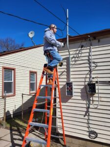 An electrician from National Electric - Lansing upgrading an outdoor electrical meter and service in Lansing, MI.