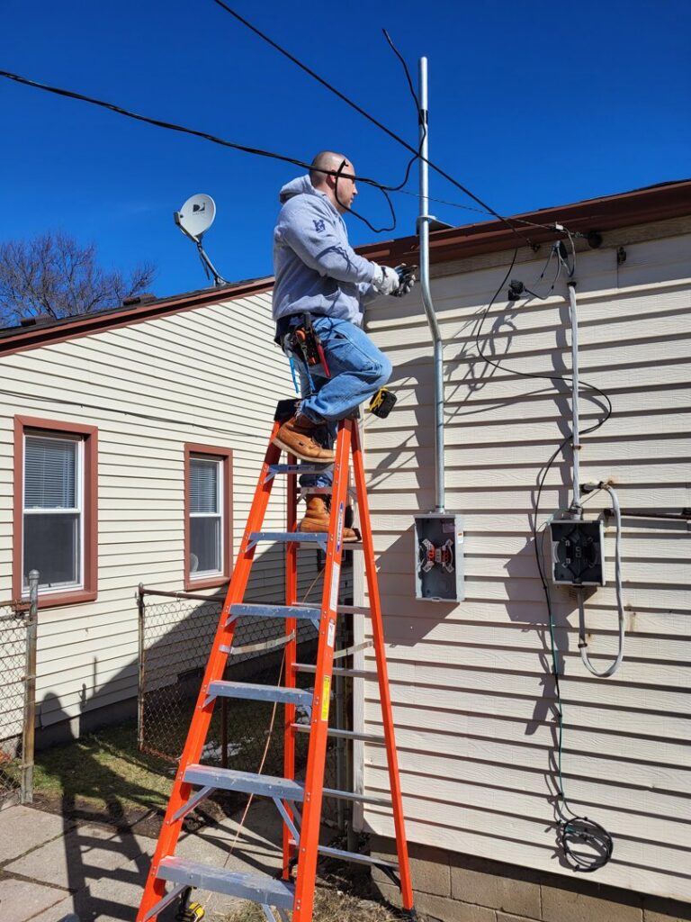 An electrician from National Electric - Lansing upgrading an outdoor electrical meter and service in Lansing, MI.