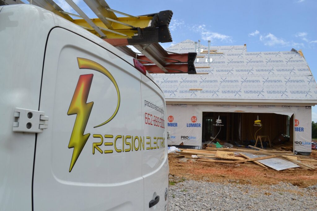 A Precision Electric and Lighting Services van parked at a new home construction site, indicating residential wiring work in Olive Branch, MS.