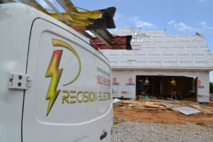 A Precision Electric and Lighting Services van parked at a new home construction site, indicating residential wiring work in Olive Branch, MS.