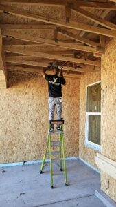 An electrician from V Electrical LLC wiring a ceiling in a new construction project in Albuquerque, NM.