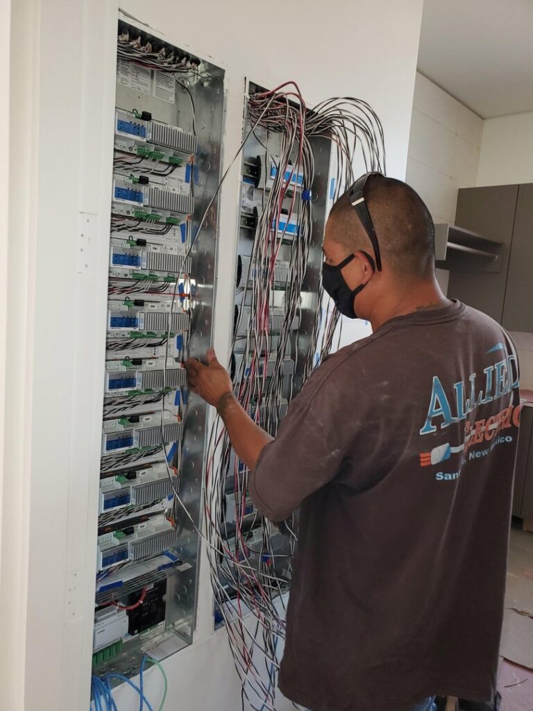 An electrician from Allied Electric wiring a complex electrical panel in Sparks, NV.
