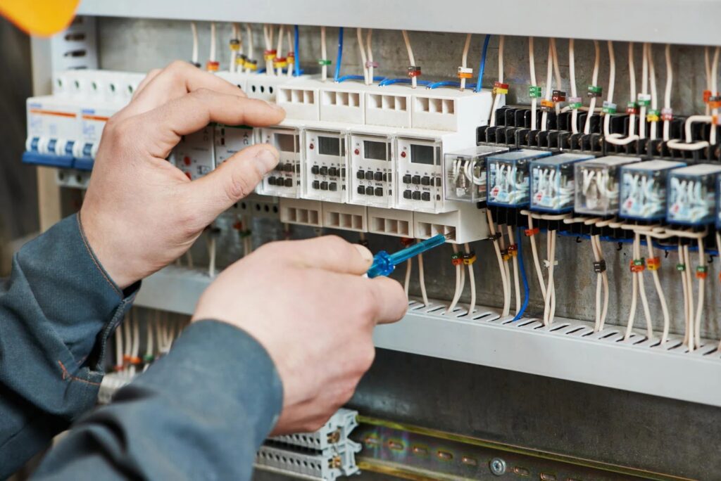An electrician meticulously wiring a control panel, showcasing expertise from Next Level Contracting LLC in Dayton, OH