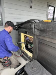 An electrician from Circuit Masters, Inc. wiring a hot tub control panel in Billings, MT.