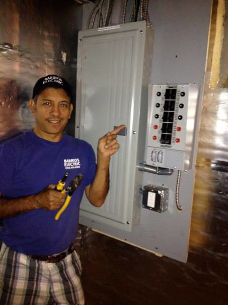An electrician from Barrios Electric LLC standing next to an electrical panel in Norwalk, CT.