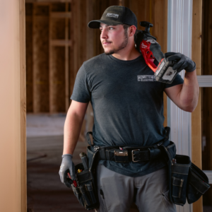 An electrician wearing a tool belt and holding a saw at a construction site for Hometown Electric in Delta, CO.