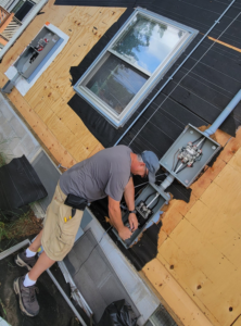 An electrician working on an outdoor electrical panel on a house for John Kivel Electric, LLC in Woodbury, MN.