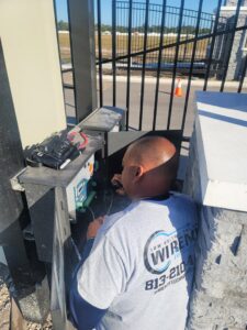 An electrician working on wiring inside a gate control box for Wirenut Technologies LLC in Brandon, FL.