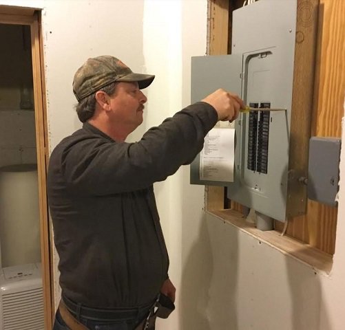 An electrician from Corbin & Maille, Inc working on a residential electrical breaker panel in Erie, PA.