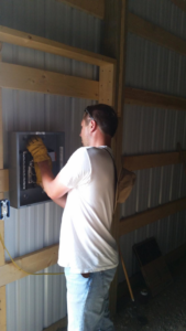 An electrician working on an electrical breaker panel inside a building for Northern Lights Electric Company in Sheridan, WY.