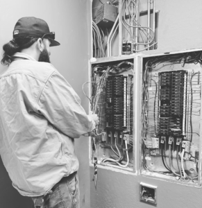 An electrician from Reuben Electrical Contracting working on an electrical breaker panel in Scottsdale, AZ.