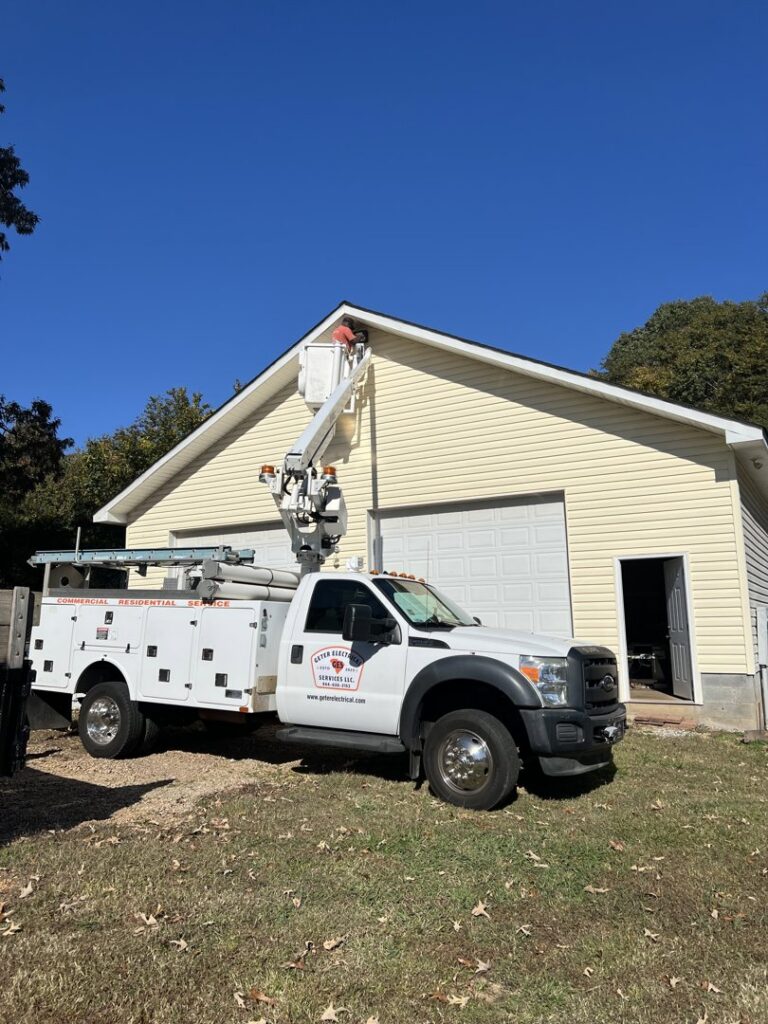 An electrician from Geter Electrical Services LLC working on a building exterior using a bucket truck in Fountain Inn, SC.