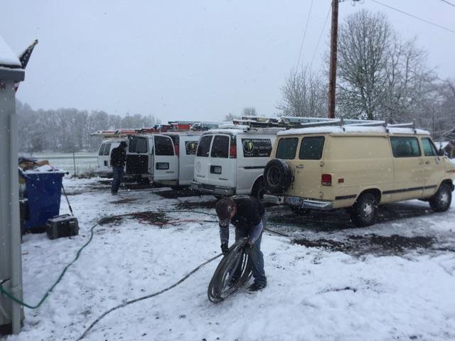 An electrician from Johnsen Electric Inc working on electrical cables outdoors in the snow in Springfield, OR.
