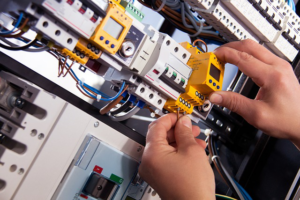 An electrician's hands working on a circuit breaker within an electrical panel for Joe Chick A/C & Electric in Zapata, TX