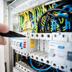 An electrician working on a circuit breaker panel with colorful wires at Jarvie Electric in Rochester, NY.