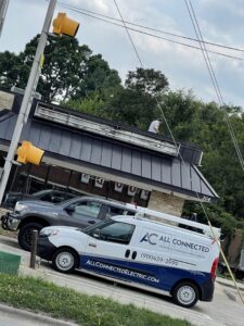 An electrician from All Connected Electric LLC working on a commercial building sign in Raleigh, NC.