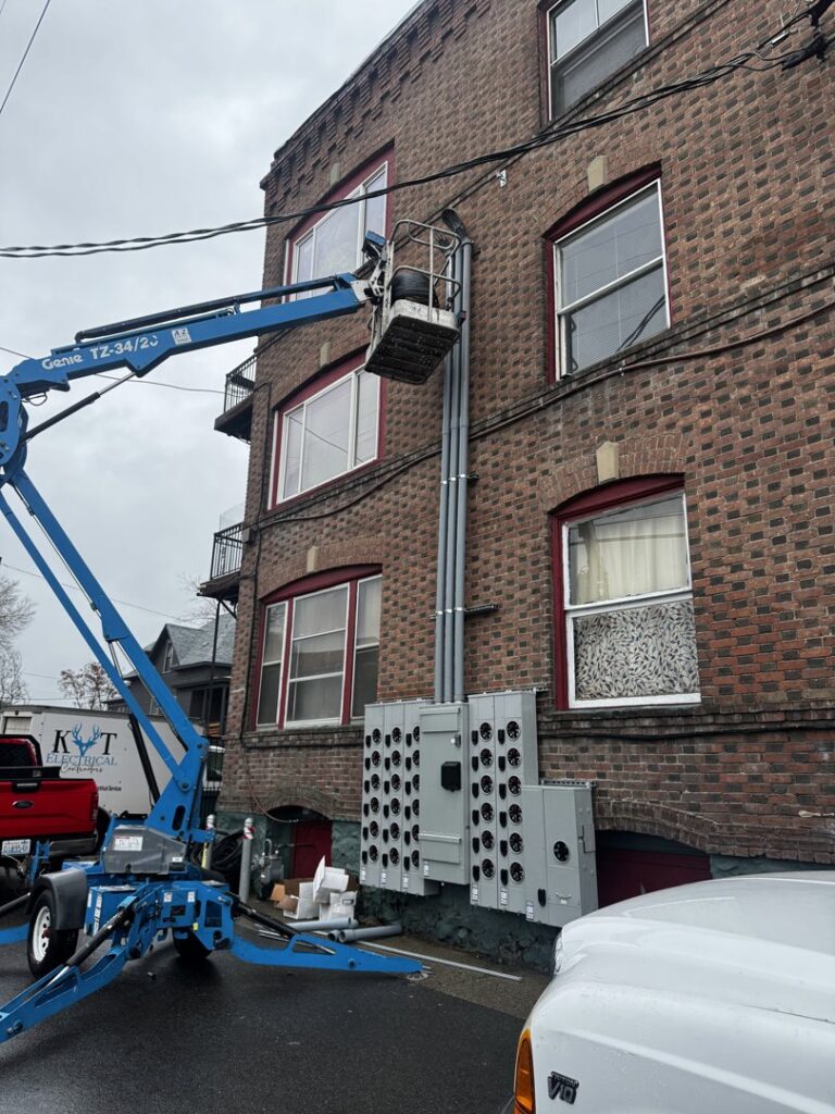 An electrician in a lift installing commercial electrical conduits and panels on a building by kt_electricalcontractors in Spokane Valley, WA