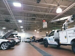 An electrician from Swartz Electric working on overhead commercial lighting from a lift bucket in Colorado Springs, CO.