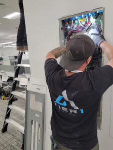 An electrician from Tier 1 Electric working on a commercial electrical panel in Boise, ID