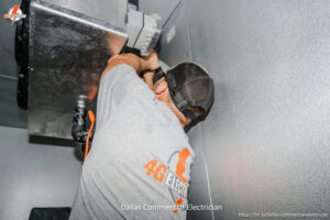 An electrician from 4G Electrician working on commercial electrical wiring in Dallas, TX