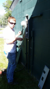 An electrician working on an outdoor electrical meter and service panel for Northern Lights Electric Company in Sheridan, WY.