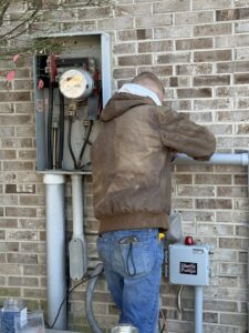An electrician from Rudis Electrical LLC working on an outdoor electrical meter and service entrance in Scranton, PA.